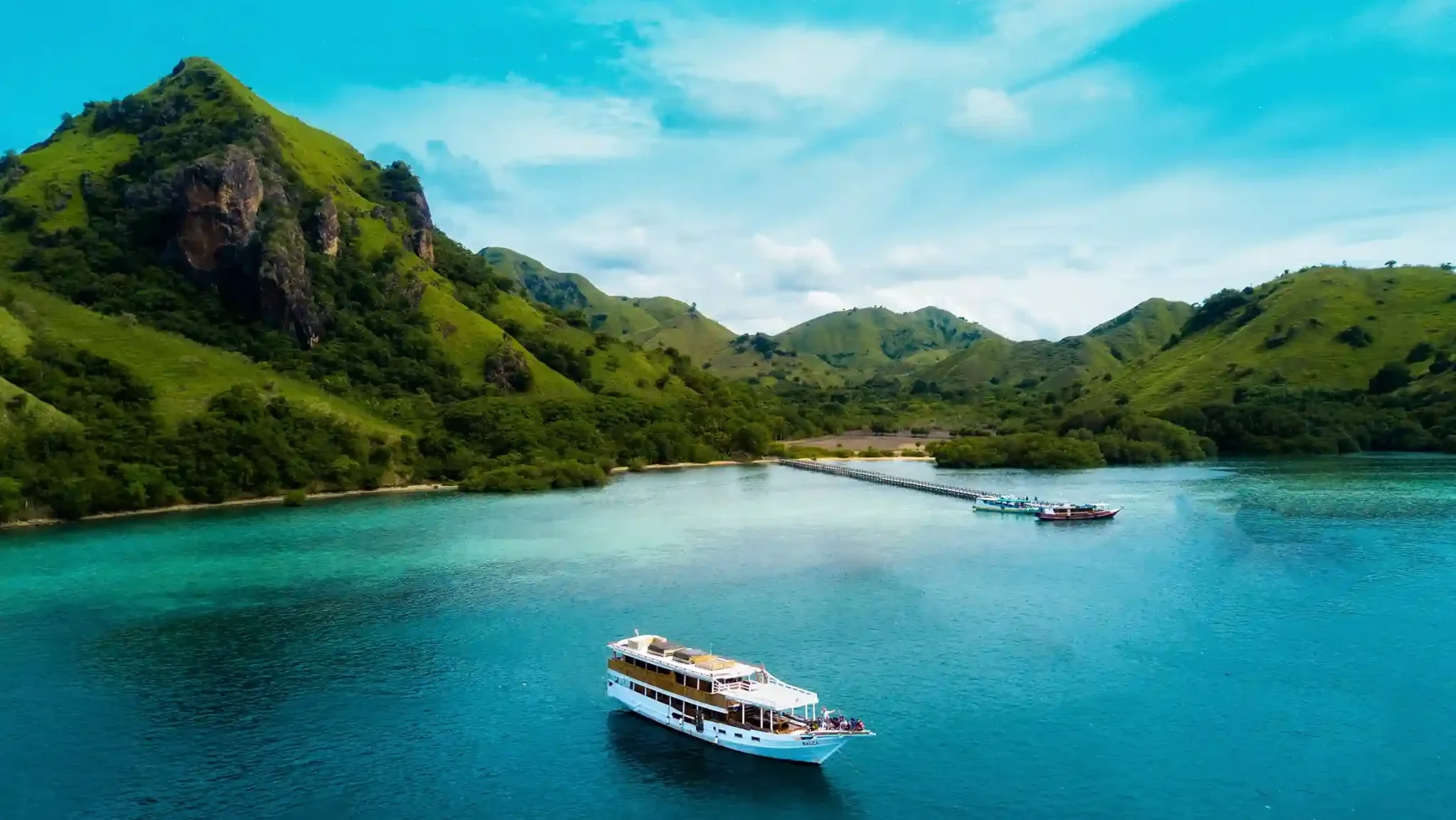 A cruise boat anchored in the turquoise bay at Manjarite Island, Komodo National Park