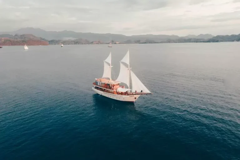 A phinisi at anchor in a quiet Komodo bay seen from above